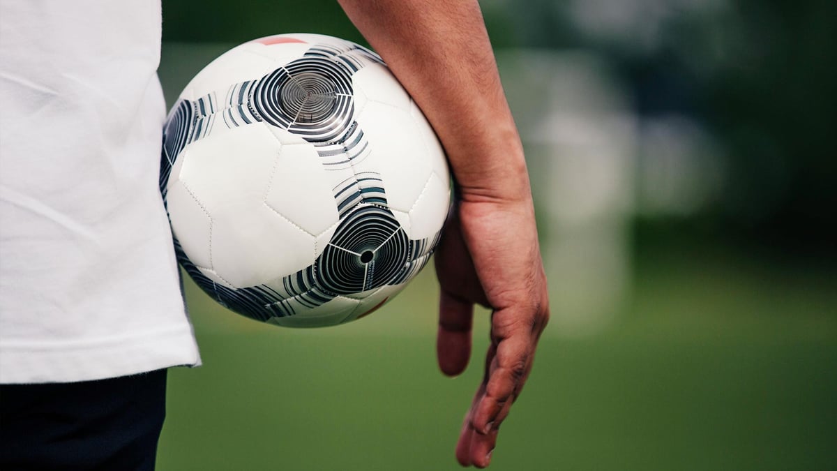 En spelare håller i en fotboll och är redo att kliva ut på planen.