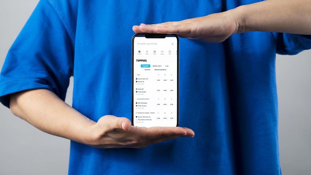 En person visar över/under-spel på mobilen.