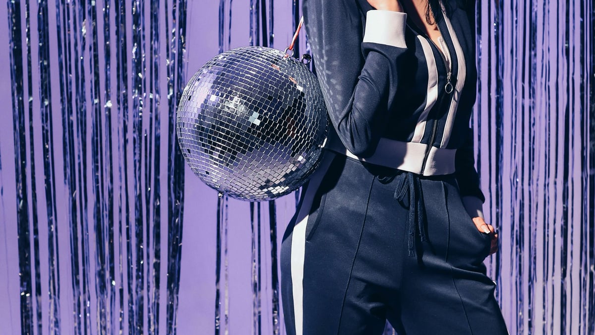 En person som gillar Eurovision håller i en discokula. 