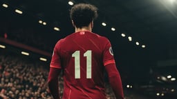 En spelare går ut på en fotbollsarena.