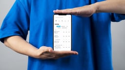 En person visar över/under-spel på mobilen.